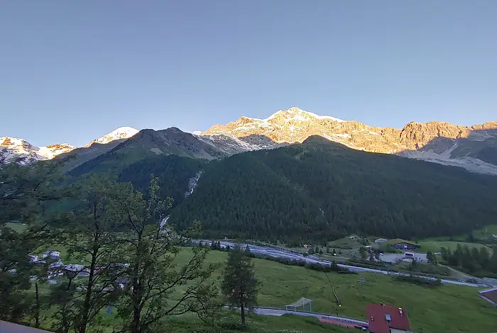 Ausblick vom Hotel Zebru auf die Berge und Wälder bei Sonnenaufgang