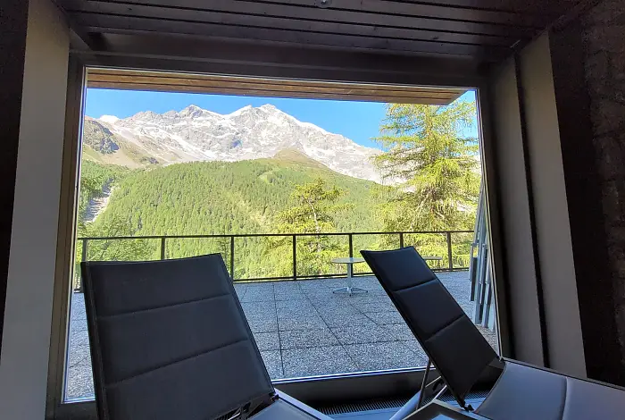 Ausblick vom Wellnessbereich auf die Terrasse mit Panoramablick auf die Berge