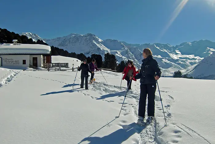 Frauen beim Schneeschuhwandern in den Bergen bei Neuschnee