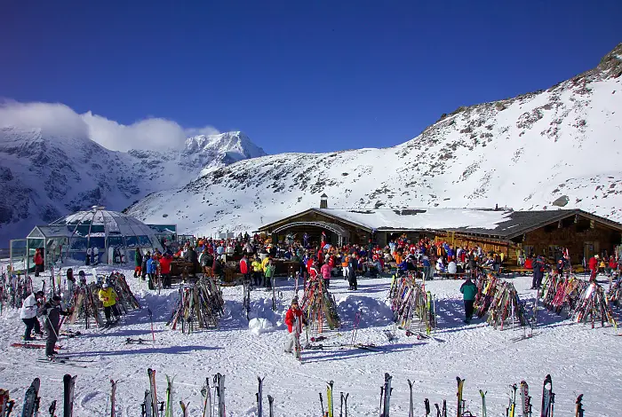 Après-Ski-Hütte und Glasiglu im Winter mit Skifahrern