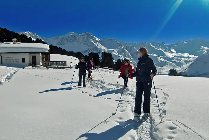 Frauen beim Schneeschuhwandern in den Bergen bei Neuschnee